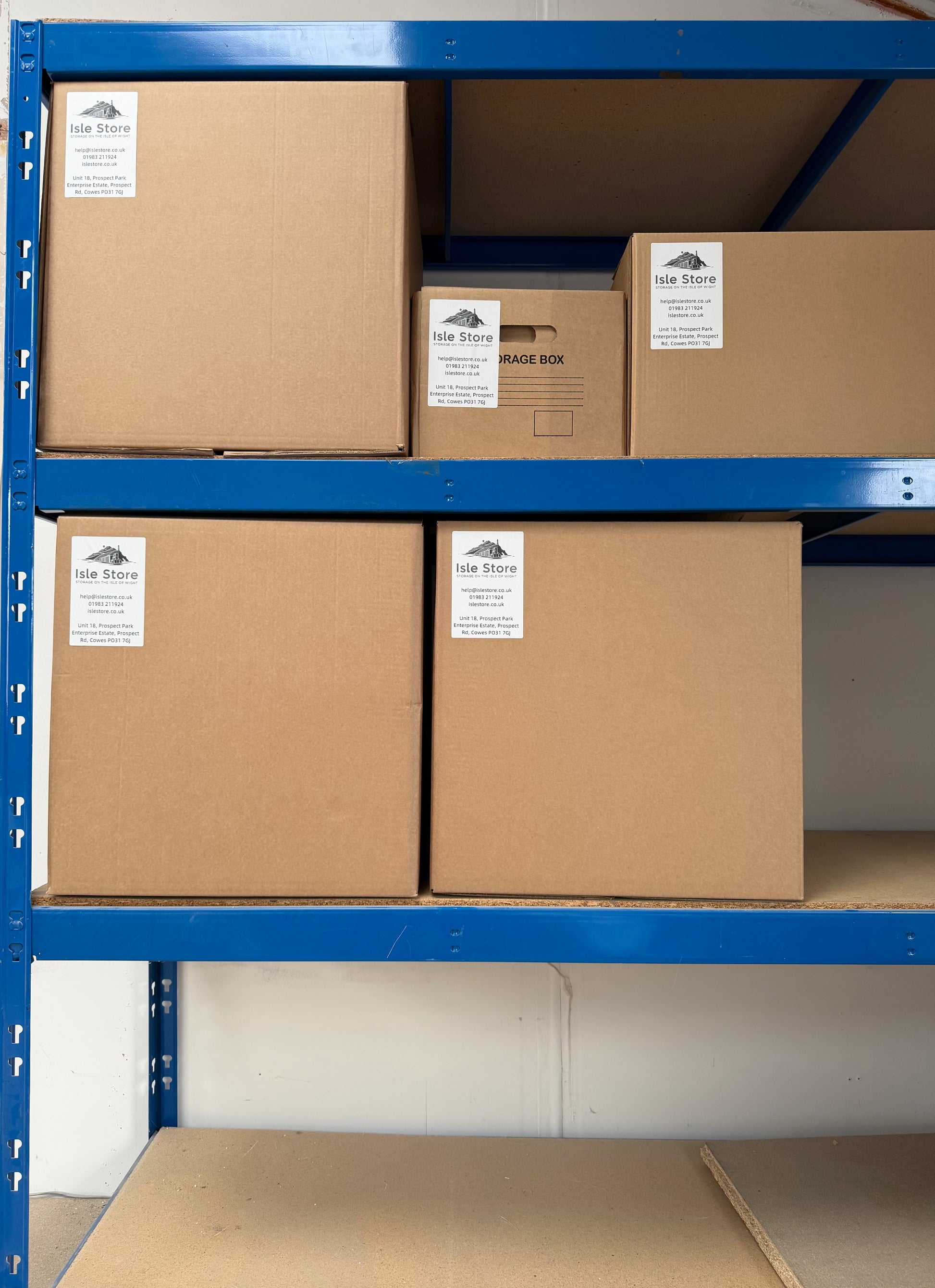 Neatly stacked and organized Isle Store 'By the Box' storage boxes on a secure metal rack inside our clean Isle of Wight warehouse.