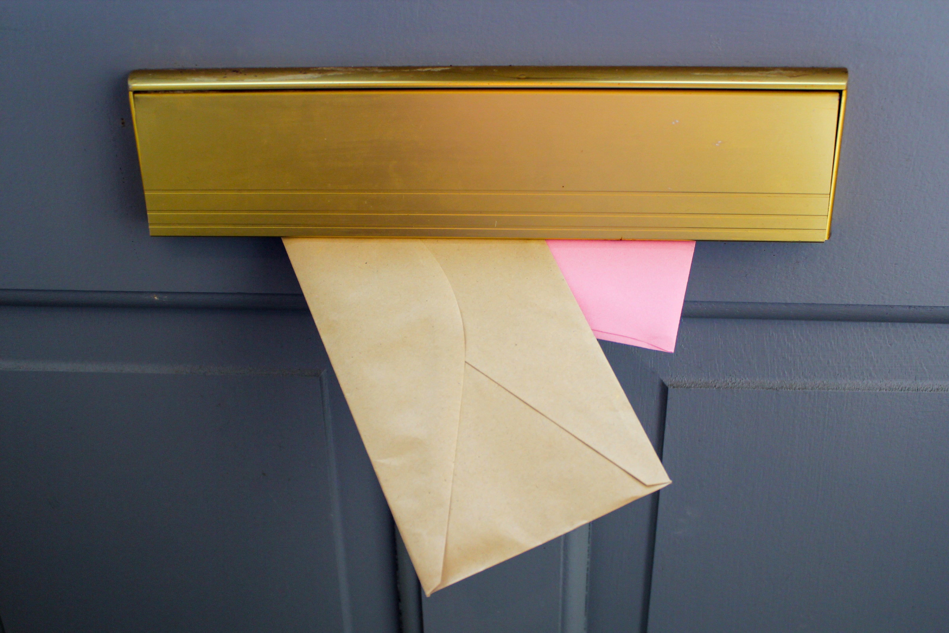 A letter being securely delivered through a letterbox, representing the professional mail handling service at Isle Store.